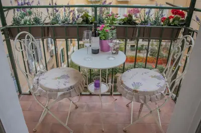 a table and two chairs on a balcony with flowers at Sleeppo B&B in Rome