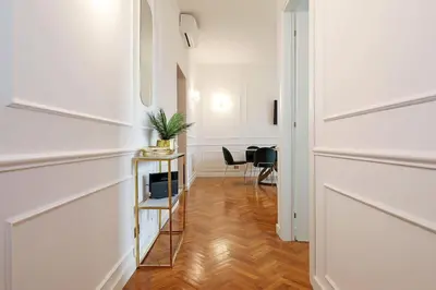 a hallway with white walls and a table with a plant on it at Jubilee Penthouse by Nosdom Properties in Rome
