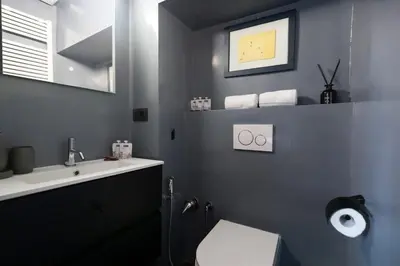 a bathroom with a sink and a toilet and a mirror at Margutta Exclusive Apartment by Romeloft in Rome