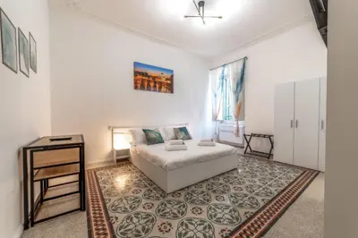 a white bedroom with a bed and a table at La Casa di Lidia - Vatican City Metro Ottaviano in Rome