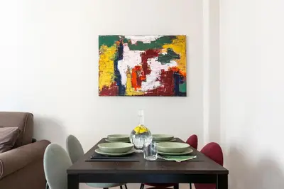 a dining room table with a painting on the wall at Casa Acaia by Hili in Rome