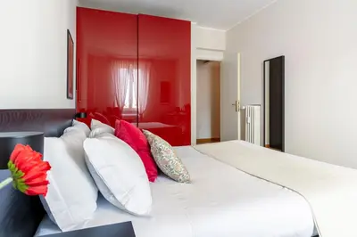 a bedroom with a large white bed with colorful pillows at Casa Acaia by Hili in Rome