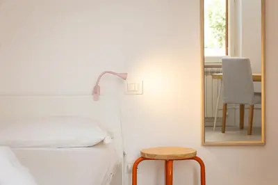 a bedroom with a mirror and a bed and a stool at Mastai Trastevere Home by Rental in Rome in Rome