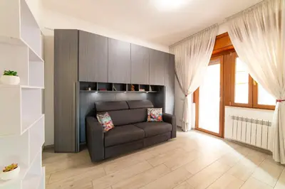 a living room with a brown couch and a window at Smart Home - Trilocale con Parcheggio Privato in Rome