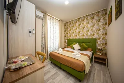 a hotel room with a green bed and a desk at Perla al Pigneto Bed and Breakfast Roma in Rome