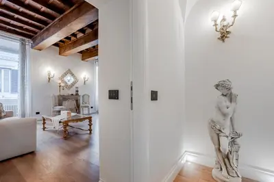 a living room with white walls and a statue on the wall at Trevi Fountain Elegant Apartment in Rome