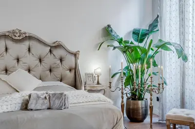 a bedroom with a bed and a large plant at Trevi Fountain Elegant Apartment in Rome