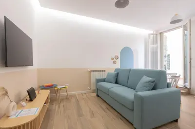 a living room with a blue couch and a table at Alba Terrace - Rome Modern Apt Close to Metro in Rome