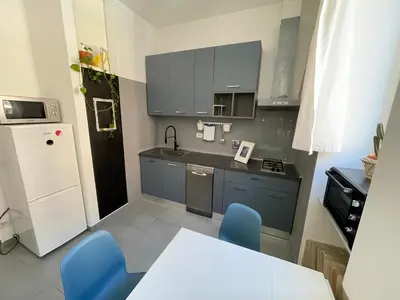 a small kitchen with a table and blue chairs at Blueberry House in Rome