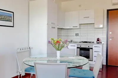 a kitchen with a glass table with a vase of flowers on it at YCH-Modern flat with terrace near Eataly in Rome