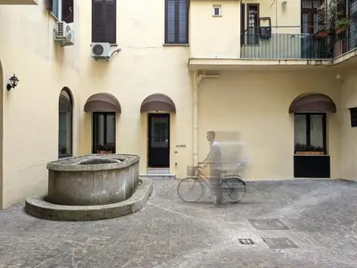 a man riding a bike in front of a building at La Corte Dei Panni in Rome