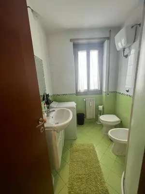 a bathroom with two sinks and a toilet and a window at Nathan House, Malatesta in Rome