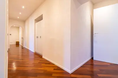 an empty hallway with white walls and wood floors at Apartment Next to St Peter in Rome