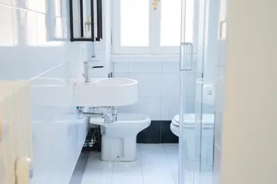 a white bathroom with a sink and a toilet at VaticaNella 10 min walk from Vatican Museums in Rome