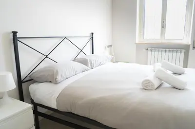 a large white bed with white towels on it at Vatican 4 BedRoom Apartment with Private Parking in Rome