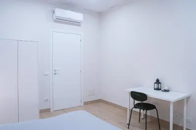 a white room with a desk and a chair at Vatican 4 BedRoom Apartment with Private Parking in Rome