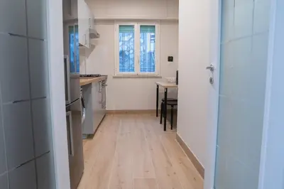 a kitchen with a wooden floor and a table at Vatican 4 BedRoom Apartment with Private Parking in Rome