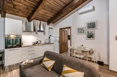a living room with a couch and a kitchen at Luciana Vatican Apartment in Rome