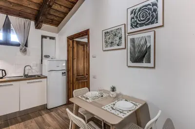 a kitchen with a table and chairs in a kitchen at Luciana Vatican Apartment in Rome