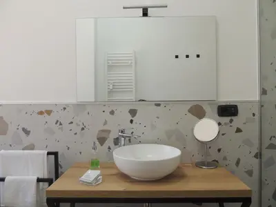 a bathroom with a white bowl sink on a wooden table at Casa Palmiero in Rome