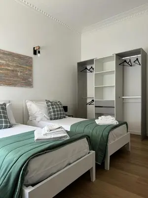 a bedroom with two beds with green sheets at Casa Palmiero in Rome