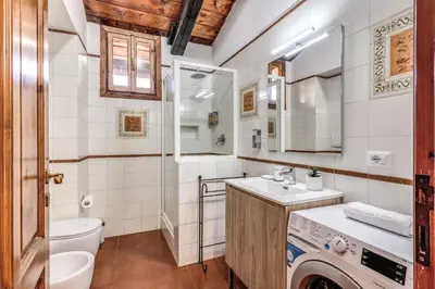 a bathroom with a sink and a washing machine at Elena Vatican Apartment in Rome