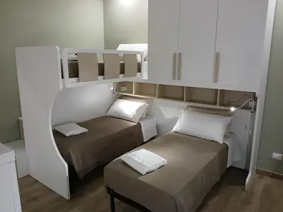 a small room with two beds and a stool at Antonella in Rome