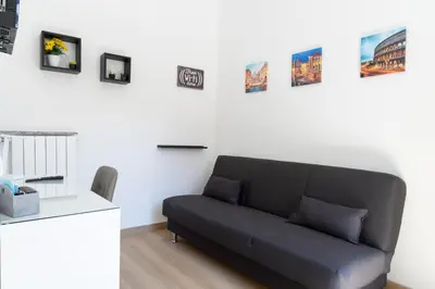 a couch in a living room with pictures on the wall at MH Luxury Suite Pantheon in Rome