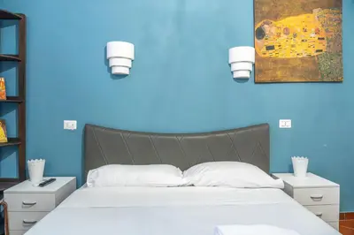 a blue bedroom with a large bed with white pillows at Lion Renting Colosseum in Rome
