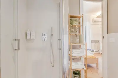 a bathroom with a shower and a shelf with towels at Domvs Domitilla in Rome