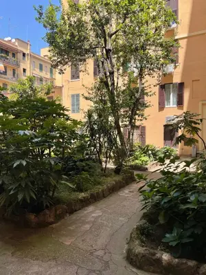 a courtyard with a tree in front of a building at AM Apartment San Giovanni in Rome