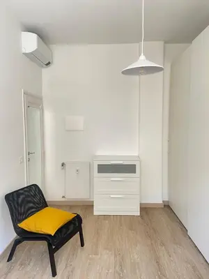 a black chair with a yellow seat in a room at AM Apartment San Giovanni in Rome