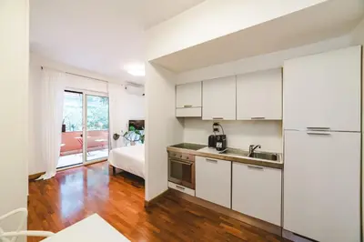 a kitchen with white cabinets and a bed in a room at Elegant Apartment Vallombrosa 55 in Rome