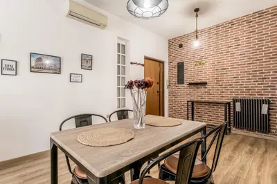 a dining room with a table with chairs and a brick wall at Inventori House in Rome