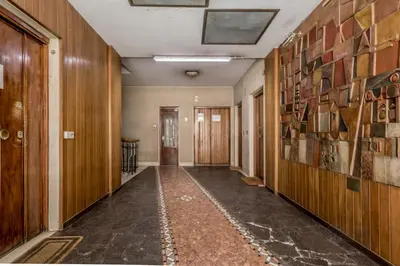 an empty hallway with wood paneled walls and a long corridor at Inventori House in Rome