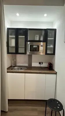a kitchen with a sink and a microwave at Colosseo Design Apartament in Rome