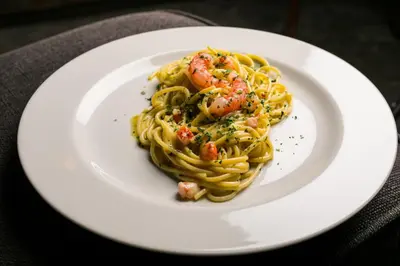 a white plate with pasta with shrimp on it at Pigneto Apartment VaDo al Pigneto Collection in Rome