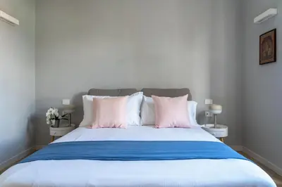 a bed with pink and blue sheets and pillows at Pigneto Apartment VaDo al Pigneto Collection in Rome