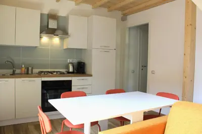 a kitchen with a white table and red chairs at Epirhome, tra Colosseo e Porta Santa in Rome