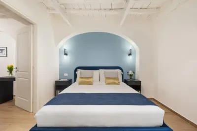 a bedroom with a large bed with a blue headboard at Leopardo Boutique Apartment in Trastevere in Rome