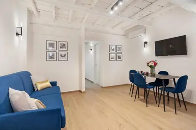a living room with a blue couch and a table at Leopardo Boutique Apartment in Trastevere in Rome