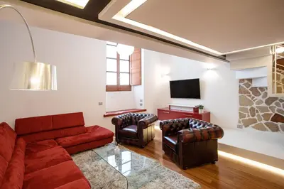 a living room with a red couch and two chairs at Pantheon Luxury Apartment in Rome