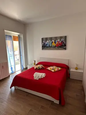a bedroom with a red bed with two towels on it at La Casa di Léon - Battistini - Vaticano in Rome