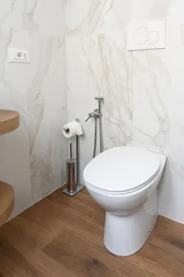 a white toilet in a bathroom with marble walls at Appartamento con 2 camere e 2 bagni -San Giovanni- in Rome