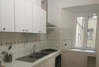 a white kitchen with a sink and a stove at Famy in Rome
