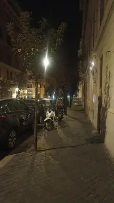 a motorcycle parked on the side of a street at night at Famy in Rome
