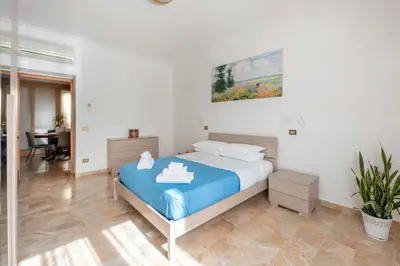 a bedroom with a large bed with a blue blanket at Apartment27 Roma in Rome