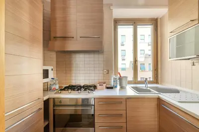 a kitchen with wooden cabinets and a stove top oven at Apartment27 Roma in Rome