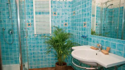 a blue tiled bathroom with a sink and a shower at TIBERIM Exclusive Rome in Rome