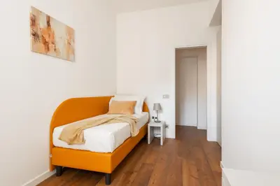 a bedroom with a bed with an orange headboard at Elegant Haven Re di Roma by Hostand in Rome